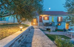 a house with a stone pathway leading to a yard at Two-Bedroom Holiday Home In Jagodnja Gornja in Gornja Jagodnja