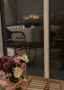 a vase of flowers sitting on a table on a balcony at شقق لافندر للشقق المخدومة الأقتصادية in Taif