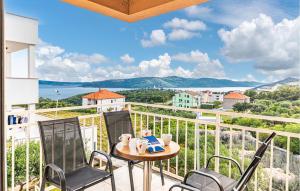 a balcony with two chairs and a table with a view at Awesome Home In Seget Donji in Seget Donji