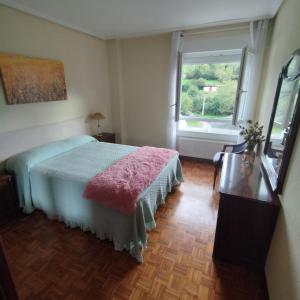 a bedroom with a bed and a window at Los Tilos in Ramales de la Victoria +10 photos