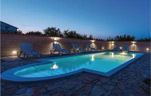 ein Pool mit Stühlen und Lampen in der Nacht in der Unterkunft Nice Home In Cista Velika With Wifi in Velika Čista