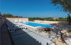 einen Pool mit weißen Stühlen und einer Feuerstelle in der Unterkunft Nice Home In Cista Velika With Wifi in Velika Čista