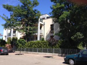a white house with cars parked in front of it at Apartament Ella in Międzywodzie