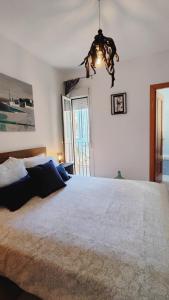 une chambre avec un grand lit et un lustre dans l'établissement La terraza de Algeciras., à Algésiras