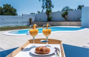 two glasses of orange juice and a pastry on a table at Gorgeous Home In Betina in Betina
