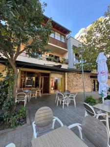 a patio with tables and chairs and an umbrella at Kida's Guest House in Librazhd