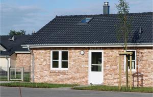 a red brick house with a white door at Stunning Home In Dagebüll With Wifi in Dagebüll