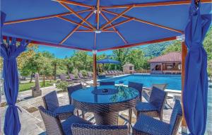 a patio with a table and chairs and a blue umbrella at Nice Home In Bribir With Sauna in Bribir +61 photos