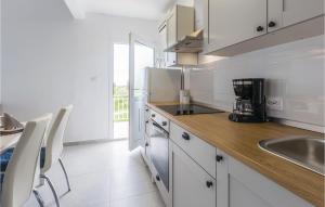 eine Küche mit weißen Schränken und einer Holzarbeitsplatte in der Unterkunft Apartment Korculanska Croatia in Poreč + 10 Fotos
