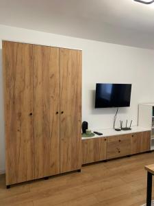 a large wooden cabinet with a flat screen tv on it at Apartament Mirka centrum in Lidzbark Warmiński