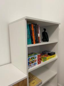 a white book shelf filled with books at Apartament Mirka centrum in Lidzbark Warmiński