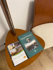 two books sitting on a table next to a chair at Apartament Mirka centrum in Lidzbark Warmiński +19 photos