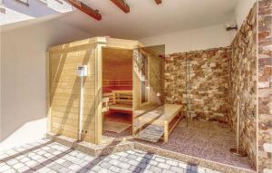 a wooden shower in a room with a brick wall at Nice Home In Bribir With Sauna in Bribir