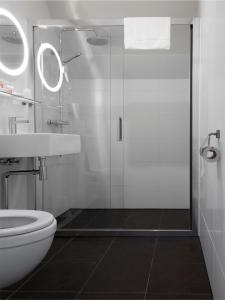 a bathroom with a shower and a toilet and a sink at Atlas Village Brielle in Brielle