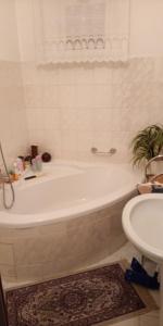 a white bath tub in a bathroom with a sink at Pension Central in Ústí nad Labem +8 photos