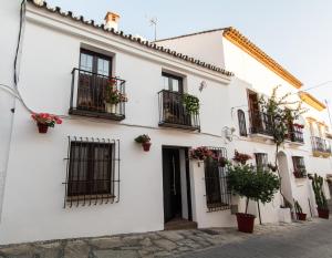 - un bâtiment blanc avec balcon et plantes en pot dans l'établissement La Casita, à Estepona