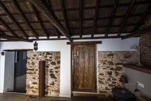 Habitación con puerta de madera y pared de piedra. en La Casita, en Estepona