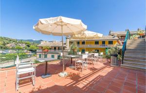 a patio with tables and chairs and an umbrella at 1 Bedroom Stunning Home In Rapallo in Rapallo