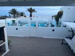 a white room with a white fence and palm trees at Casa Lento ARIES 11 in Tías