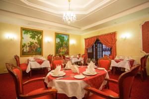 a dining room with tables and chairs and a chandelier at Rasstal Spa Hotel in Naberezhnyye Chelny