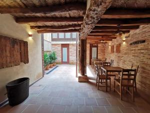 a dining room with tables and chairs and a brick wall at Ca la Pubilla in Masroig
