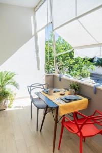 uma mesa e cadeiras num quarto com janelas em Vele d'Otranto B&B em Otranto