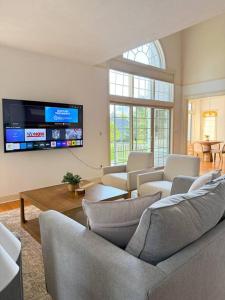 a living room with couches and a flat screen tv at Cozy Ithaca Retreat - Fenced Yard - 7 min to Cornell in Ithaca +49 photos