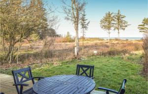 ein blauer Tisch und Stühle auf einer Terrasse mit Strand in der Unterkunft Holiday Home Kystagervej Odder Iv in Odder