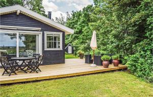 eine Holzterrasse mit Tisch und Sonnenschirm in der Unterkunft Holiday Home Kystagervej Odder Iv in Odder