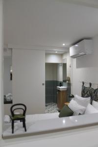 a room with a bed and a chair in it at Entre Linhas in Coimbra