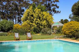two chairs sitting next to a swimming pool at Luxury Poolside Villa Irene in Cape Town