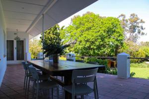 a wooden table and chairs on a patio at Luxury Poolside Villa Irene in Cape Town