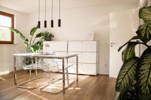 a dining room with a glass table and a refrigerator at Ferienwohnung am Bollrich in Goslar