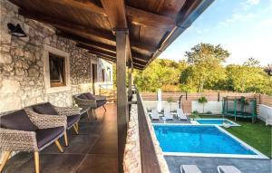 une terrasse avec une piscine et des chaises à côté d'une maison dans l'établissement Beautiful Home In Tribalj, à Tribalj