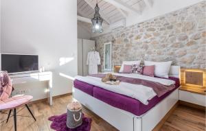 une chambre avec un grand lit et un mur en pierre dans l'établissement Beautiful Home In Tribalj, à Tribalj
