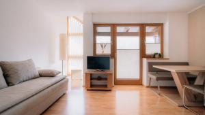 a living room with a couch and a television at Apart Gipfelglück in Längenfeld