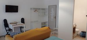 a living room with a yellow couch and a desk at CasaRA in Bari