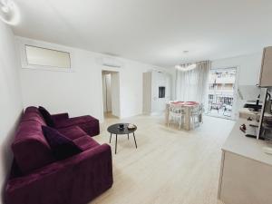 a living room with a purple couch and a table at Avornic's House in Porto Santa Margherita di Caorle
