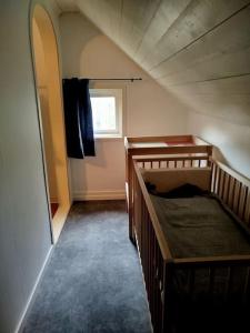 a attic room with two bunk beds and a window at 85qm Schwedenhaus mit Booten Tischtennis Grill und nur 15km bis Vimmerby in Södra Vi