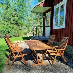a wooden picnic table and chairs in front of a house at 85qm Schwedenhaus mit Booten Tischtennis Grill und nur 15km bis Vimmerby in Södra Vi