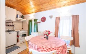 a kitchen with a table with a vase of flowers on it at Beautiful Home In Gruda With Wifi in Gruda