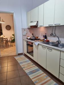 une cuisine avec des armoires blanches et un four à plaques de cuisson dans l'établissement La Casa più Bella, à Custonaci