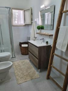 une salle de bains avec lavabo, toilettes et miroir dans l'établissement La Casa più Bella, à Custonaci 27 autres photos