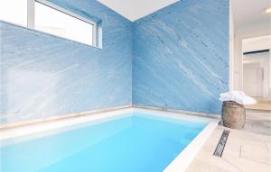 une piscine dans une pièce avec un mur bleu dans l'établissement Beach Front Home In Lembruchdümmer See, à Lembruch