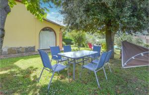 a table and chairs under a tree in a yard at Lovely Home In Cortona With Kitchen in Cortona