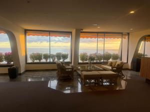 a living room with a view of the ocean from windows at Penthouse Montemarina primera línea Anfi del Mar in Mogán