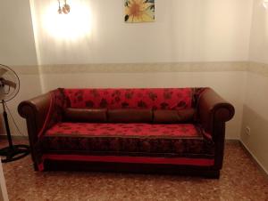 un divano rosso seduto in un angolo di una stanza di Appartamento Levante a Bari Altre 21 foto