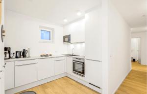 a white kitchen with white cabinets and a sink at Penthouse Deluxe in Lembruch