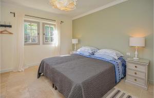 ein weißes Schlafzimmer mit einem Bett und einem Fenster in der Unterkunft L'amandier in Saint-Rémy-de-Provence