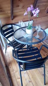 a glass table and chairs on a wooden deck at Lago Cristal Chalets in Bucaramanga